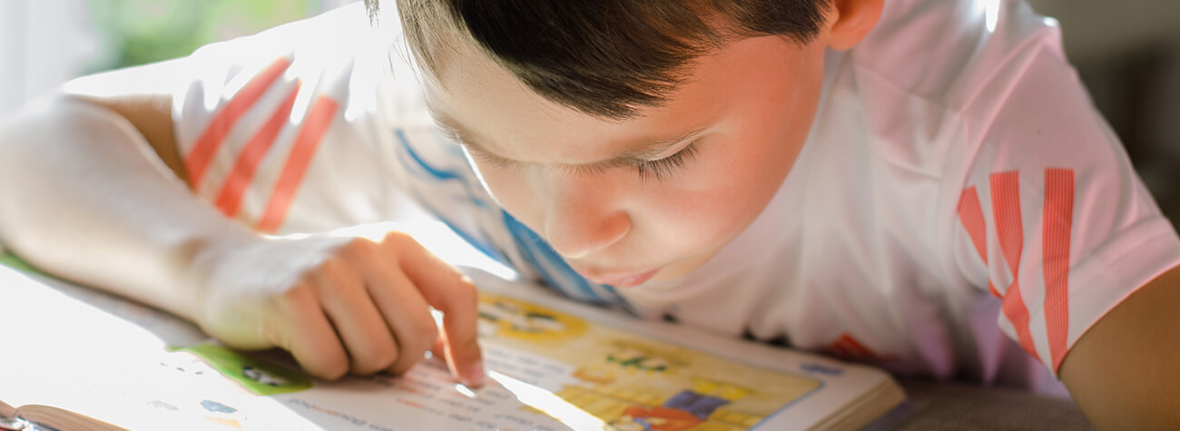 Child with Dyslexia Reading from Book